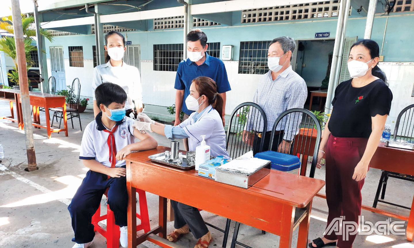 BSCK2 Võ Thành Nhơn và lãnh đạo Trung tâm Y tế TP. Mỹ Tho giám sát tiêm chủng cho trẻ em tại Trường THCS Bảo Định, TP. Mỹ Tho vào sáng 20-4-2022.
