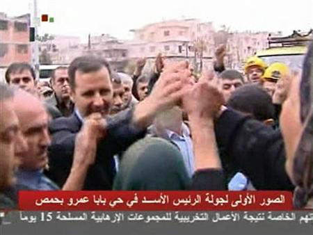 Tổng thống Syria Bashar al-Assad bắt tay với những người ủng hộ địa phương trong một chuyến thăm khu phố Baba Amr Homs