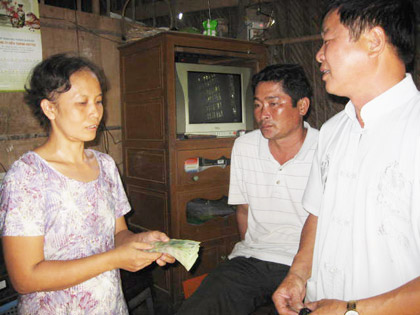 Đại diện doanh nghiệp trao tiền cho chị Nhung.