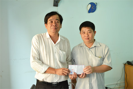 Anh Lê Thanh Vũ trao tiền ủng hộ cho đại diện Báo Ấp Bắc.