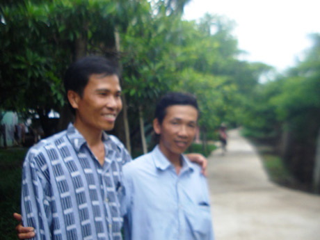 Anh Trần Văn Sơn (phải) và anh Huỳnh Văn Thành trước con đường vừa mới đổ dal.