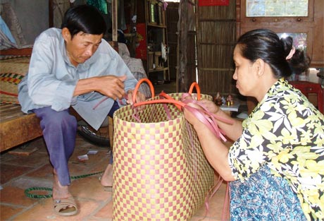 Vợ chồng anh Nguyễn Văn Tuyền và công việc kết quai giỏ bẹ.
