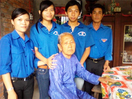 Anh Tú (bìa phải) cùng sinh viên tình nguyện thăm mẹ liệt sĩ nhân ngày 27-7.