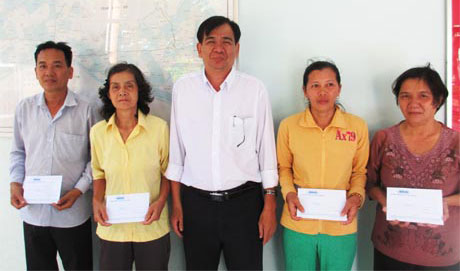 Ông Nguyễn Minh Tân, Phó Tổng Biên tập Báo Ấp Bắc trao học bổng cho đại diện gia đình của sinh viên.