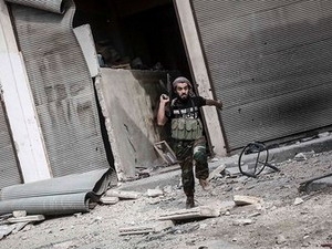 Một tay súng của quân nổi dậy cố hắng thoát khỏi một điểm giao tranh ở Aleppo, ngày 24-10. Ảnh: AP