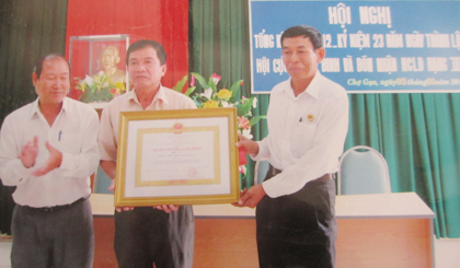 Phó Chủ tịch UBND huyện Chợ Gạo Lê Văn Mỹ trao Huân chương Lao động hạng Ba cho đại diện Hội CCB huyện.