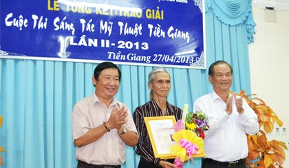 Ông Trần Thanh Phúc, Phó Giám đốc Sở VH-TT&DL cùng ông  Nguyễn Huỳnh Anh, Chủ tịch Hội Văn học - Nghệ thuật tỉnh trao giải I  cho Họa sĩ Lê Hồng Thái.