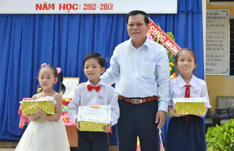 Chủ tịch UBND tỉnh Nguyễn Văn Khang trao phần thưởng cho học sinh như lời mong ước của em Hồ Quốc Chương.