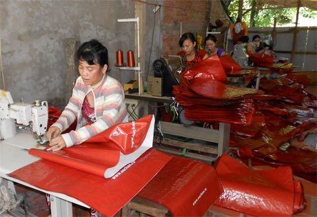 Lao động nông thôn làm việc trong một cơ sở may gia công túi xách tại xã Tân Bình, huyện Cai Lậy.