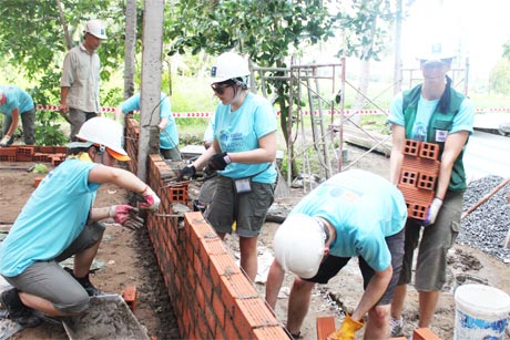 Tình nguyện viên quốc tế xây dựng nhà cho người nghèo xã Hòa Định. Ảnh: PHƯƠNG MAI