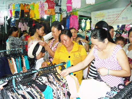 Người dân mua sắm hàng hóa tại một phiên chợ hàng Việt ở xã Phú Đông (huyện Tân Phú Đông).