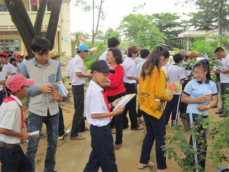 Bà Liên (mặc áo đỏ) đang trao tập cho học sinh trường THCS Tân Hương.