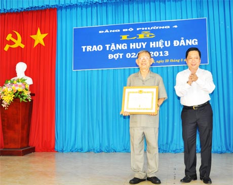 Bí thư Tỉnh ủy Trần Thế Ngọc trao Huy hiệu 65 năm tuổi Đảng cho đồng chí Huỳnh Văn Niềm.