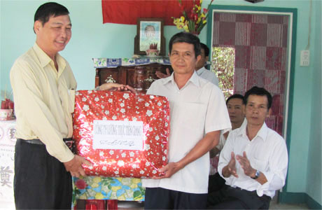Ông Nguyễn Quốc Trực, Giám đốc Công ty Lương thực Tiền Giang tặng quà cho gia đình.