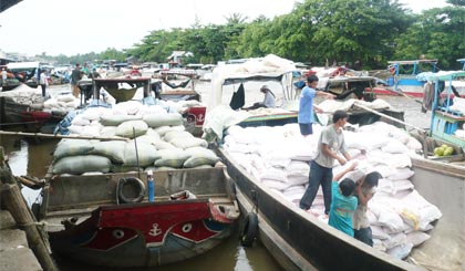 Thương lái thu mua gạo ở chợ Bà Đắc (huyện Cái Bè).