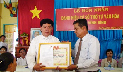 Ông Ngô Văn Tuấn, Chủ tịch UBND huyện trao Quyết định công nhận cơ sở thờ tự văn hóa cho Ban Cai quản Thánh thất Cao Đài Vĩnh Bình.