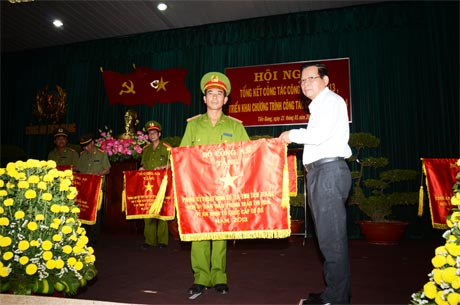 Ông Nguyễn Văn Khang, Chủ tịch UBND tỉnh trao Cờ của Bộ Công an tặng Phòng Kỹ thuật hình sự.