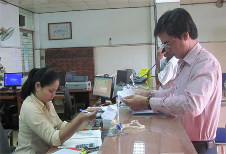 Khách hàng sử dụng dịch vụ bưu chính tại một điểm giao dịch của Bưu điện Tiền Giang.