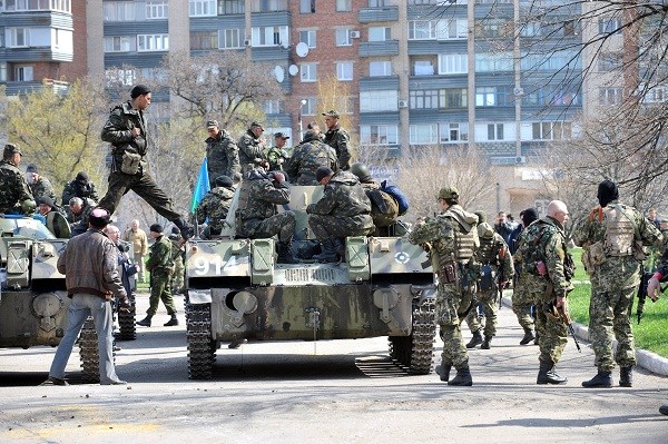 Xe bọc thép của một nhóm vũ trang chưa rõ thuộc lực lượng nào trấn giữ bên ngoài một tòa nhà chính quyền ở thành phố Slavyansk ngày 16/4. AFP/TTXVN phát