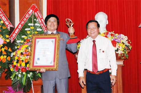 Chủ tịch UBND tỉnh Nguyễn Văn Khang trao Cúp Giải thưởng chất lượng Quốc gia cho ông Trần Đỗ Liêm, Chủ tịch HĐQT HTX Rạch Gầm.