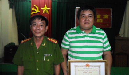 Trung tá Trương Thanh Hòa, Đội phó  Đội Xây dựng phong trào và phụ trách xã  về ANTT - Công an huyện trao giấy khen.