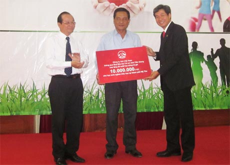 Ông Trần Thanh Đức, Phó Chủ tịch UBND tỉnh và đại diện AIA Việt Nam trao bảng tượng trưng hỗ trợ 10 triệu đồng cho học sinh nghèo hiếu học.