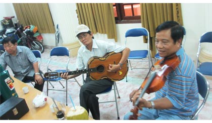 Danh cầm Đức Huệ nổi tiếng với ngón đờn Guitar tay trái  và cây violon “vàng” Thanh Nhàn trong một buổi tập.