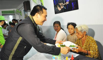  Linh mục JB Nguyễn Tấn Sang ân cần trao cơm cho khách.
