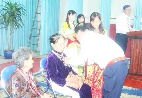 Ông Nguyễn Văn Khang, Chủ tịch UBND tỉnh gắn Huy hiệu và trao danh hiệu vinh dự Nhà nước Bà mẹ Việt Nam anh hùng cho các mẹ.