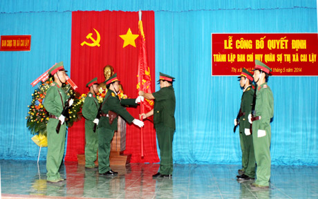 Thiếu tướng Nguyễn Xuân Tỷ - Phó Tư lệnh Quân khu 9 trao Quân kỳ Quyết thắng cho Ban CHQS thị xã Cai Lậy.