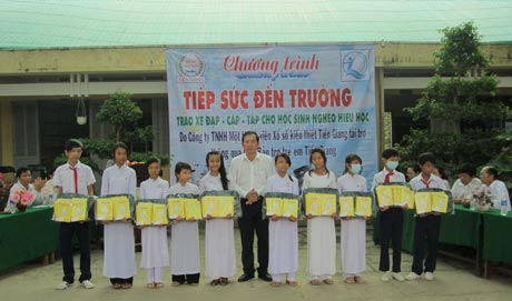 Ông Hồ Thanh Sơn, Phó Giám đốc Sở LĐ-TB&XH trao quà cho học sinh vượt khó học tốt.