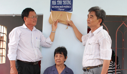 Ông Hồ Thanh Phong, bà Phùng Muối, ông Đoàn Văn Trước, Phó Chủ tịch MTTQ xã Mỹ Phong gắn bảng tặng nhà