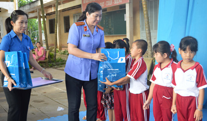 bà Nguyễn Thị Ánh Phó viện trưởng VKS tỉnh, ông Lê Văn Vũ Phó chủ tịch xã Cai Lậy trao quà cho các em.