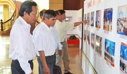 Các đại biểu tham quan triển lãm thành tựu về kinh tế - xã hội của huyện Tân Phước tại hội thảo.