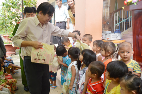 Ông Nguyễn Minh Tân, Phó Tổng Biên tập Báo Ấp Bắc phát quà trung thu cho các em học sinh.