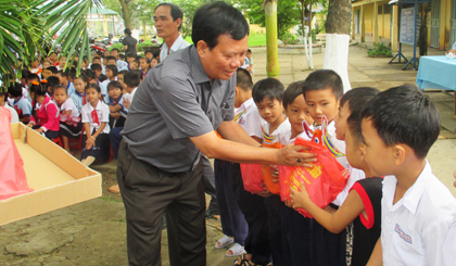  ông Huỳnh Văn Tính, Phó Chủ tịch Liên Hiệp các tổ chức hữu nghị Tiền Giang trao quà trung thu cho các cháu học sinh Trường Tiểu học Phước Trung 1