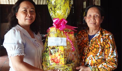 Bà Võ Ngọc Phương, Phó Chi cục trưởng Chi cục Thuế  huyện Chợ Gạo tặng quà gia đình ông Phạm Thế Truyền.