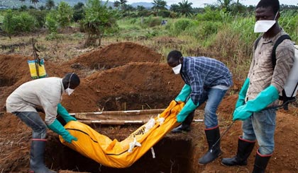 Nhân viên tình nguyện trong trang phục bảo hộ chôn xác nạn nhân Ebola tại Waterloo, cách thủ đô Freetown, Sierra Leone khoảng 30km ngày 7-10. Ảnh: AFP/TTXVN