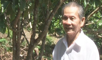 Ông Dương Thành Quản trong vườn cây ăn trái của gia đình.