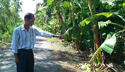 Ông Trần Văn Ron trên phần đất hiến tặng để mở rộng tuyến đường giao thông nông thôn.