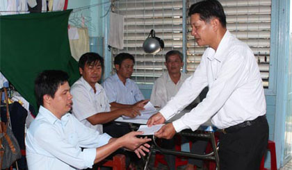 Ông Nguyễn Văn Nên, Chánh văn phòng Ban ATGT tỉnh thăm, tặng quà cho anh Lê Minh Hùng (ấp 2, xã An Hữu, huyện Cái Bè)