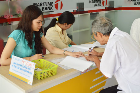 Chi trả lương hưu cho người thụ hưởng tại điểm giao dịch của Bưu điện Tiền Giang. Ảnh: Vân Anh