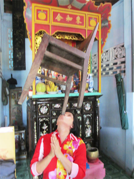 Chị Nguyễn Thị Thúy ôn lại môn múa ghế trước khi đi múa cúng miễu.
