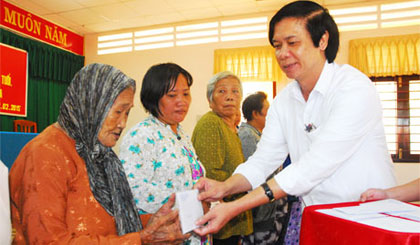 Ông Nguyễn Văn Danh, Phó Bí thư Thường trực Tỉnh ủy, Chủ tịch HĐND tỉnh trao quà cho các hộ nghèo ở thị trấn Tân Hòa.
