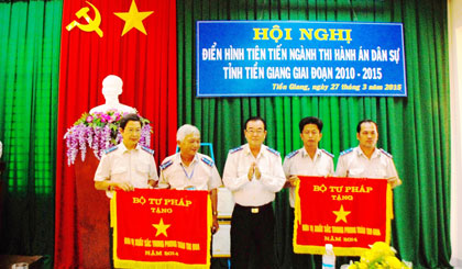 Ông Nguyễn Văn Quyết, Cục trưởng Cục Thi hành án dân sự tỉnh trao Cờ thi đua xuất sắc của Bộ Tư pháp cho 2 tập thể.