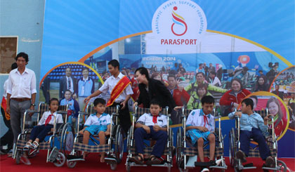 Bà Huỳnh Thanh Tuyền, Giám đốc Quỹ tài trợ thể thao Para Sport Việt Nam trao xe lăn cho học sinh khuyết tật.