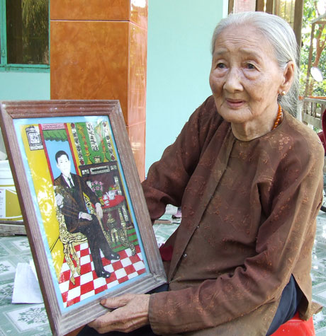 Bà mẹ VNAH Trần Thị Bảy bùi ngùi xem lại di ảnh của con.