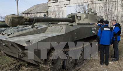 Các thành viên OSCE tại Ukraine kiểm tra xe bọc thép của lực lượng ly khai Cộng hòa Nhân dân Donetsk tự xưng. Ảnh: AFP/TTXVN