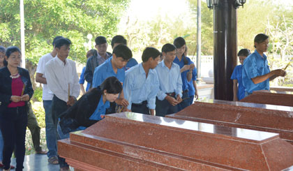 Đoàn viên trong đoàn thắp hương nơi mộ 3 chiến sỹ gang thép.