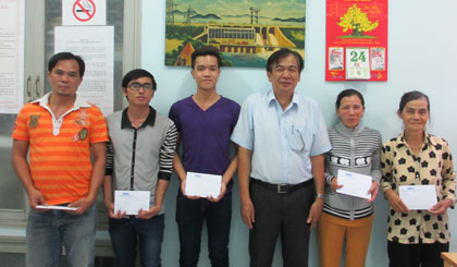Ông Nguyễn Minh Tân, Phó Tổng biên tập báo Ấp Bắc trao học bổng cho sinh viên và đại diện gia đình.